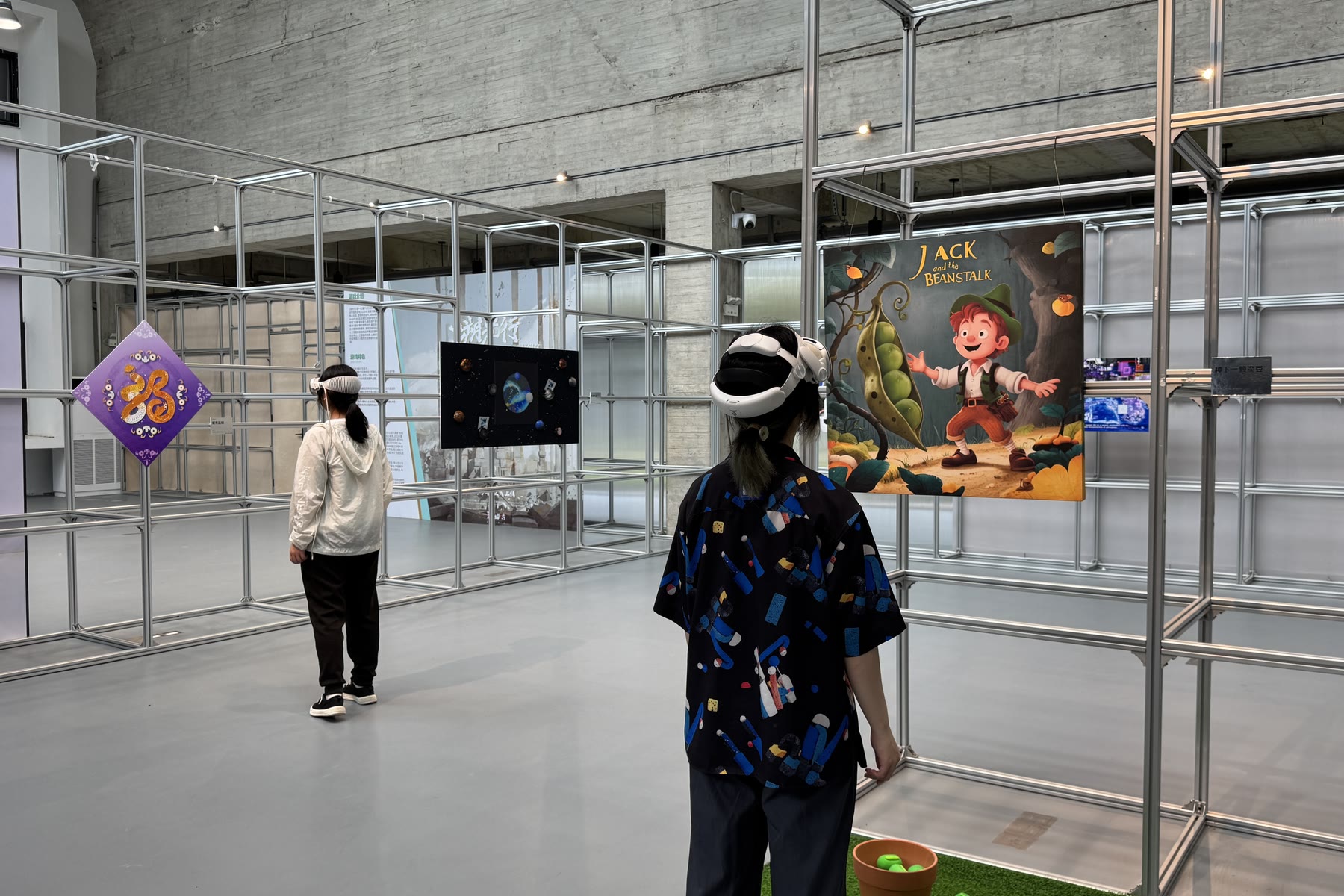 A student in a headset in front of a printed work at the exhibition